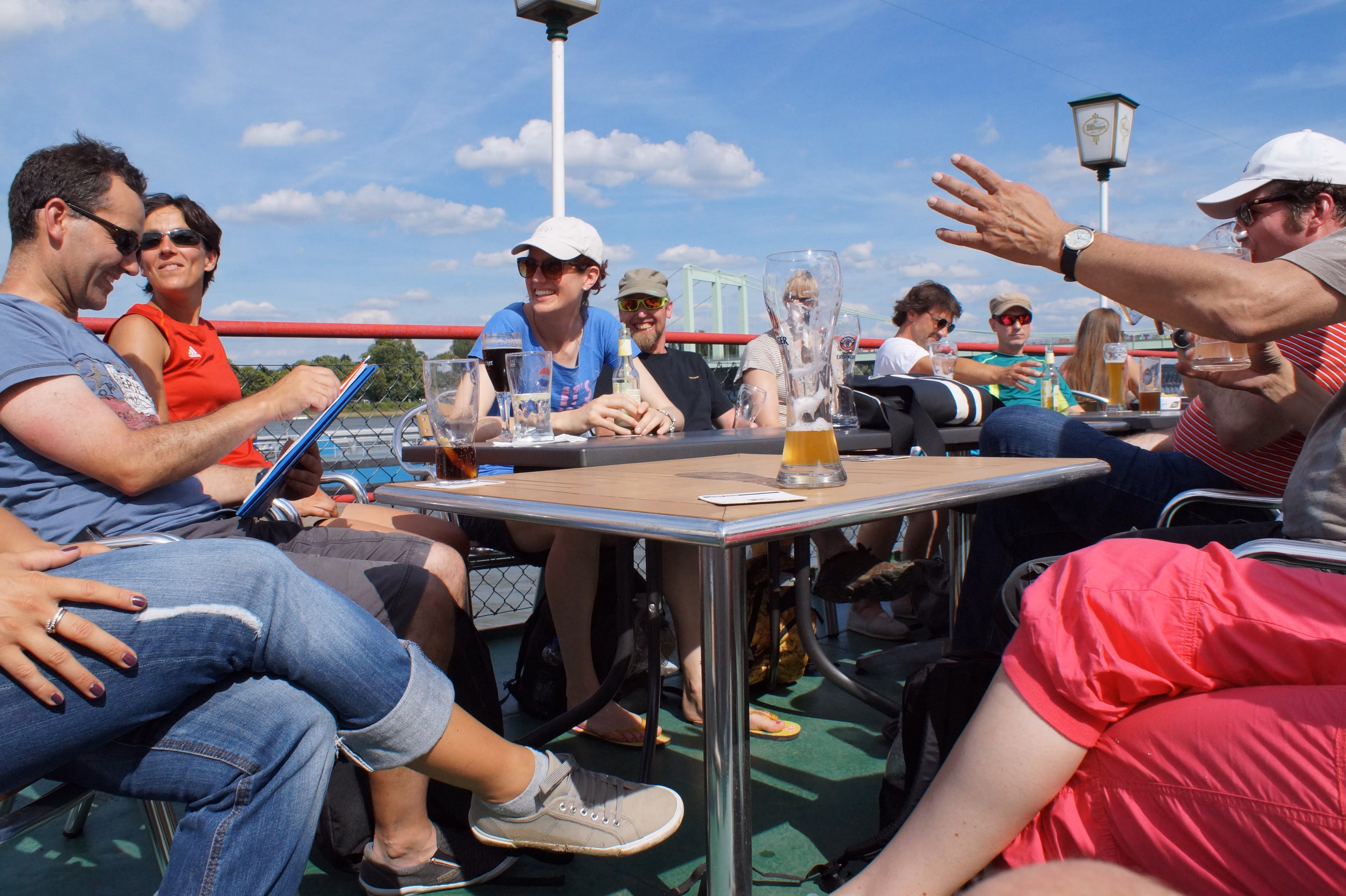 Teilnehmende einer Rafting-Tour sitzen nach der Tour an einem Tisch mit Getränken