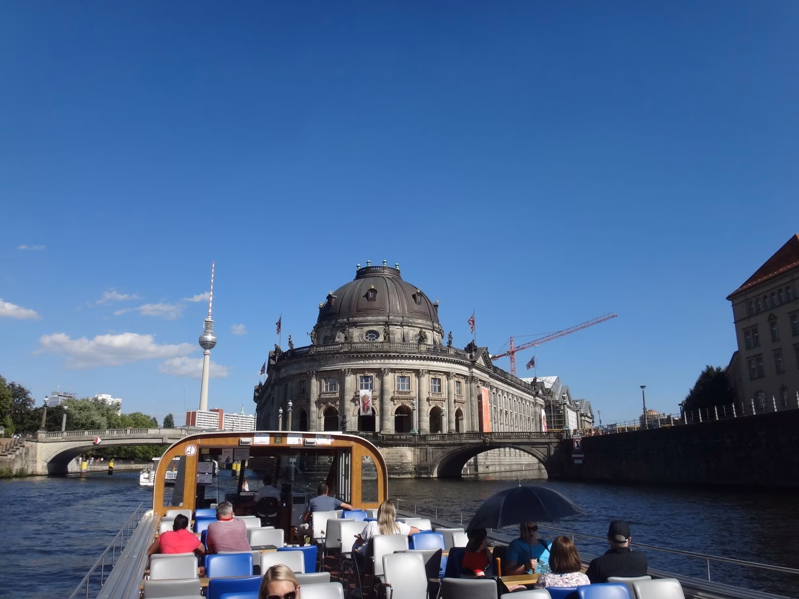 Personen auf einem Fahrgastschiff bei einer City-Tour auf der Spree durch Berlin