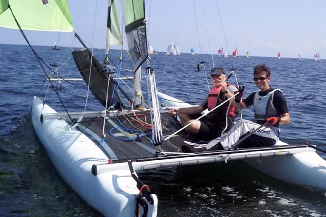 Zwei Personen segeln auf einem Katamaran in der Ostsee.