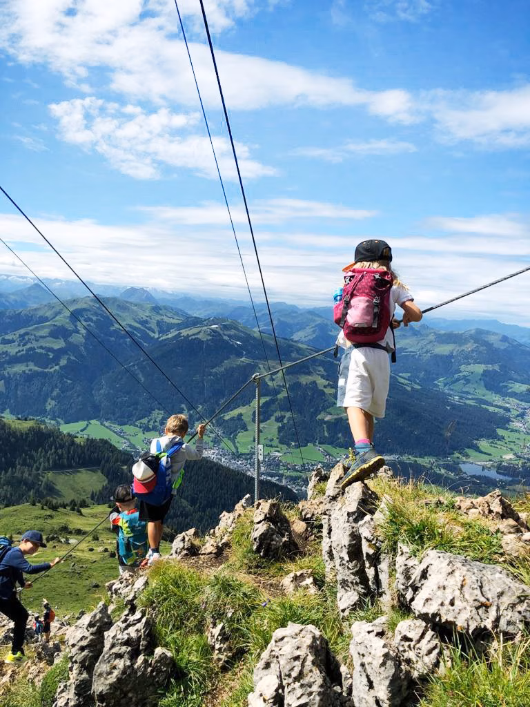 Kinder gehen einen Klettersteig bei Kitzbühel