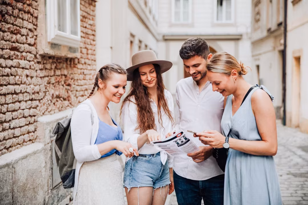 Vier Personen stehen in einer Gasse und schauen sich die Papier-Unterlagen des Krimi-Trail Grömitz an.
