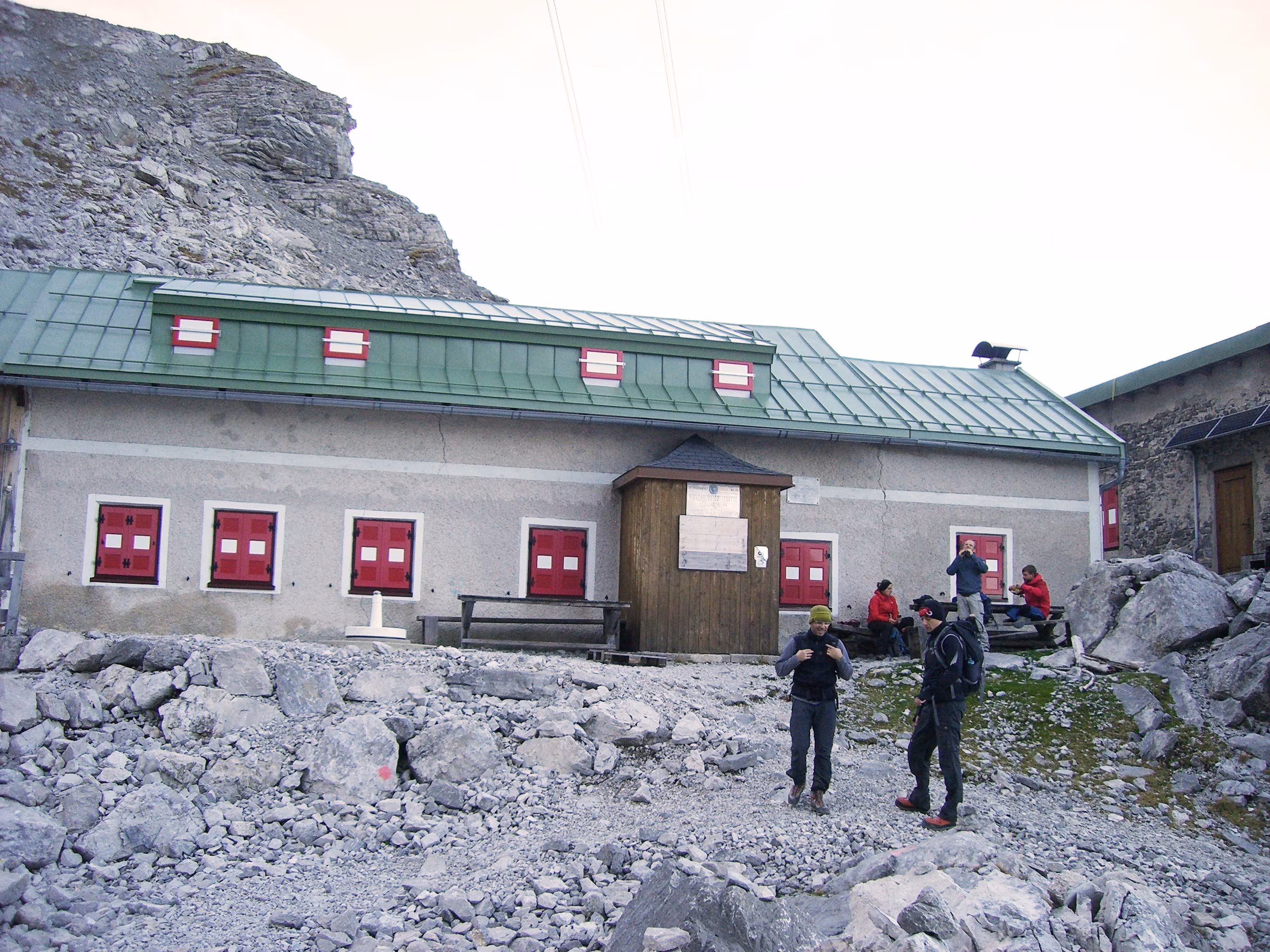 Menschen vor einer Hütte in den Alpen bei einer geführten Klettersteig-Tour