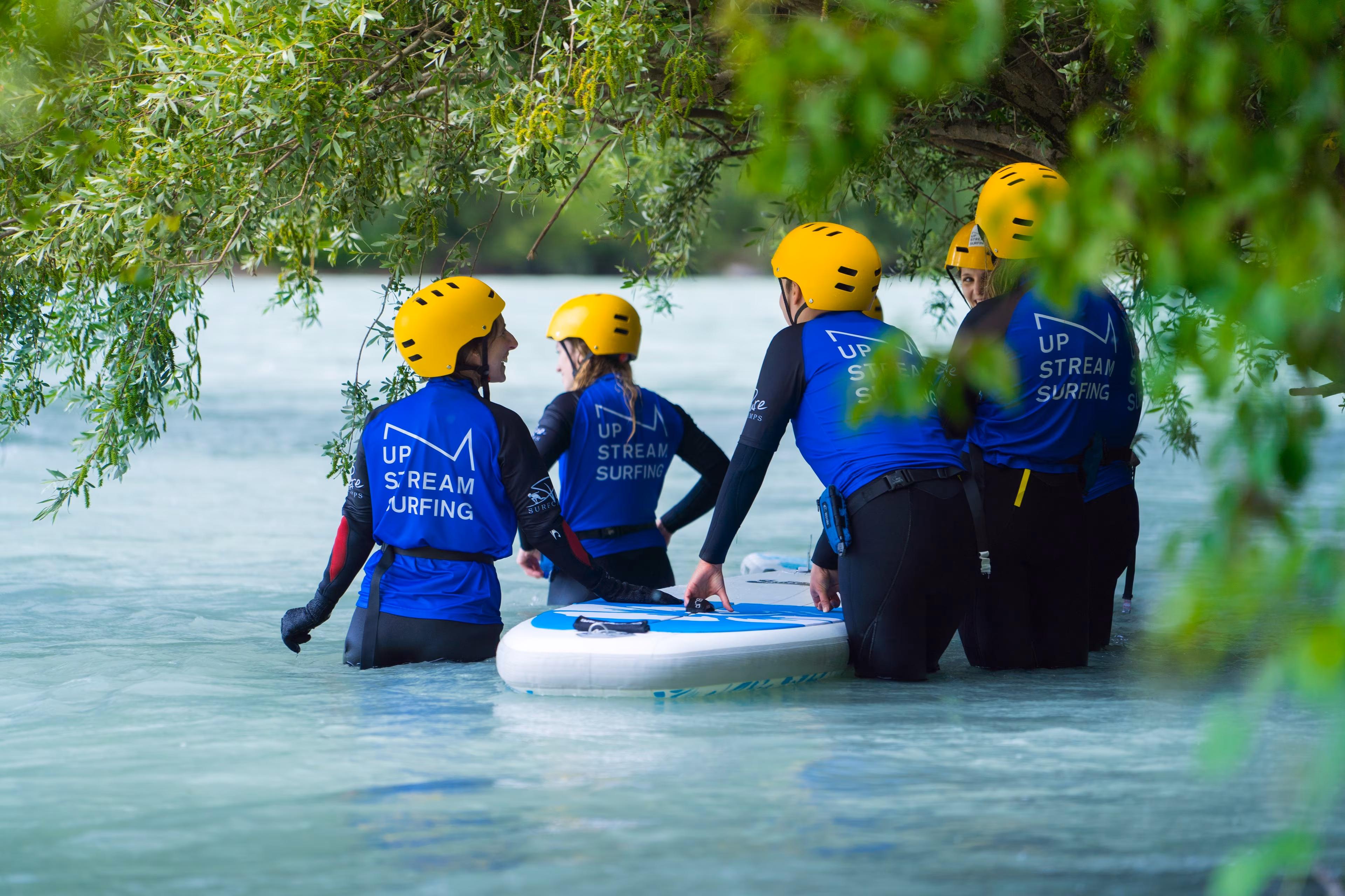 Eine Gruppe erhält eine Einweisung ins Fluss-Surfen auf dem Inn