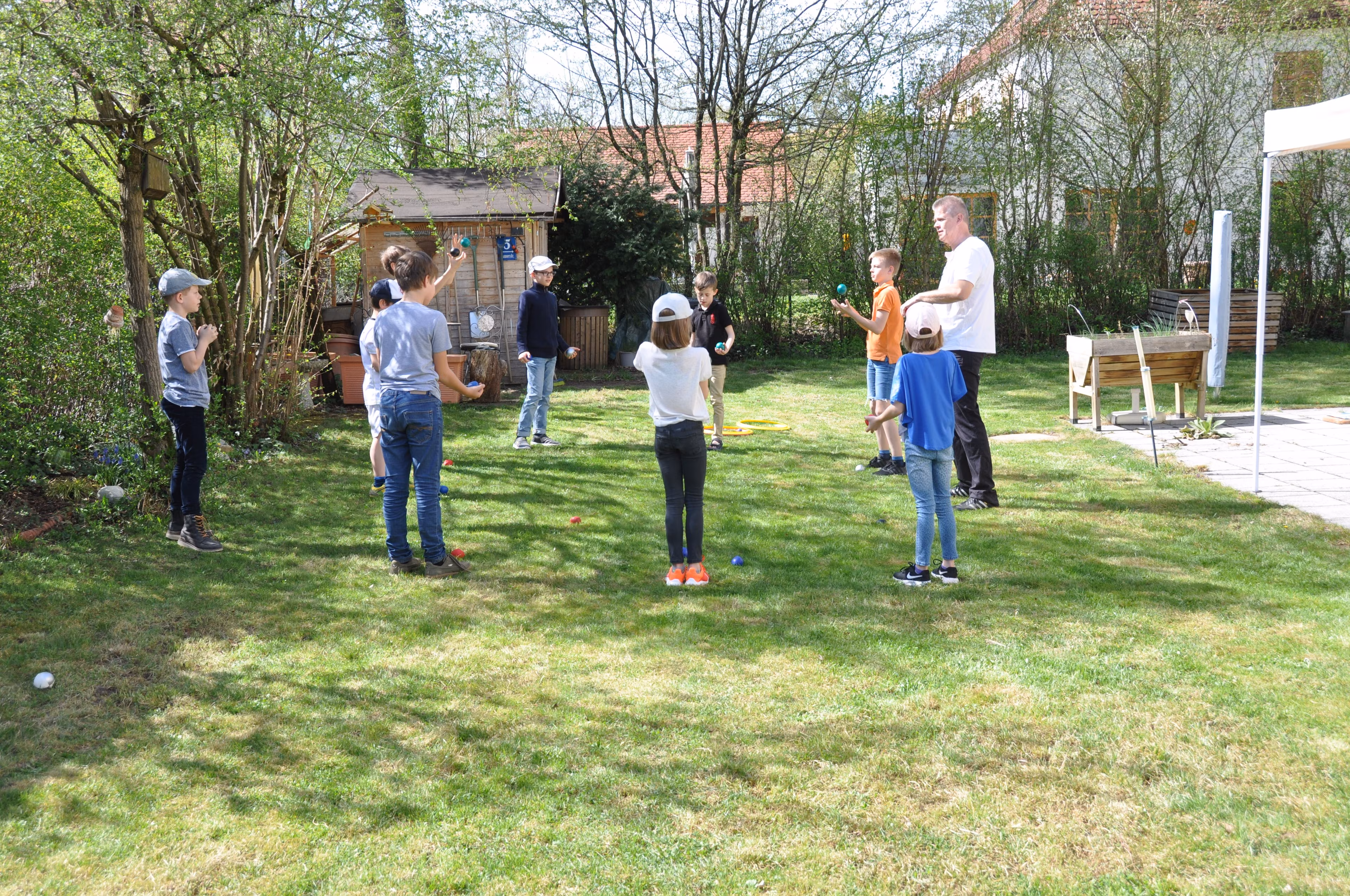 Kinder werfen bei einem Jonglier-Workshop in München Bälle in die Höhe