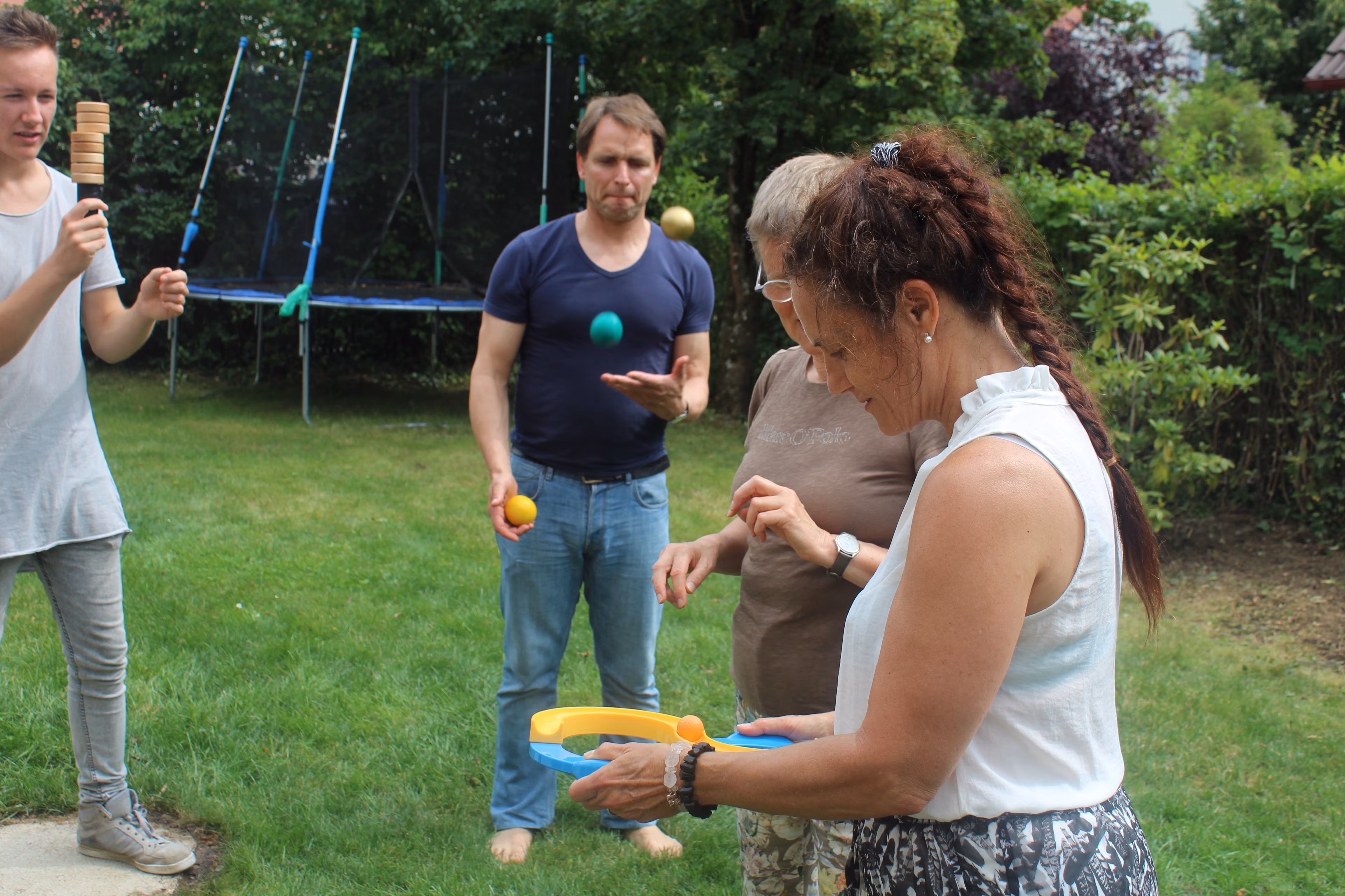 Teilnehmende eines Jonglier-Workshops werfen Bälle in die Höhe