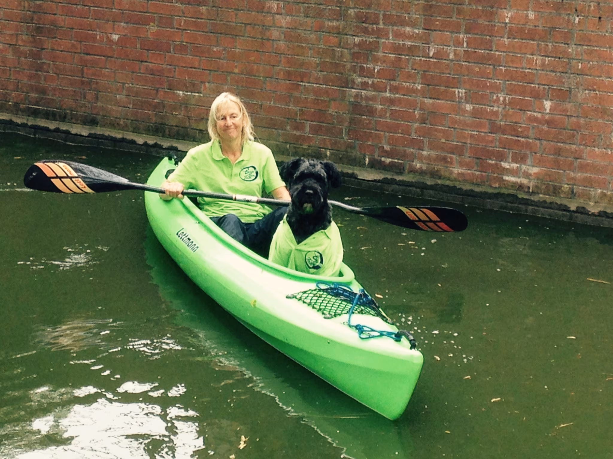 Eine Frau mit Hund paddelt 2 in einem Kajak auf der Lohne
