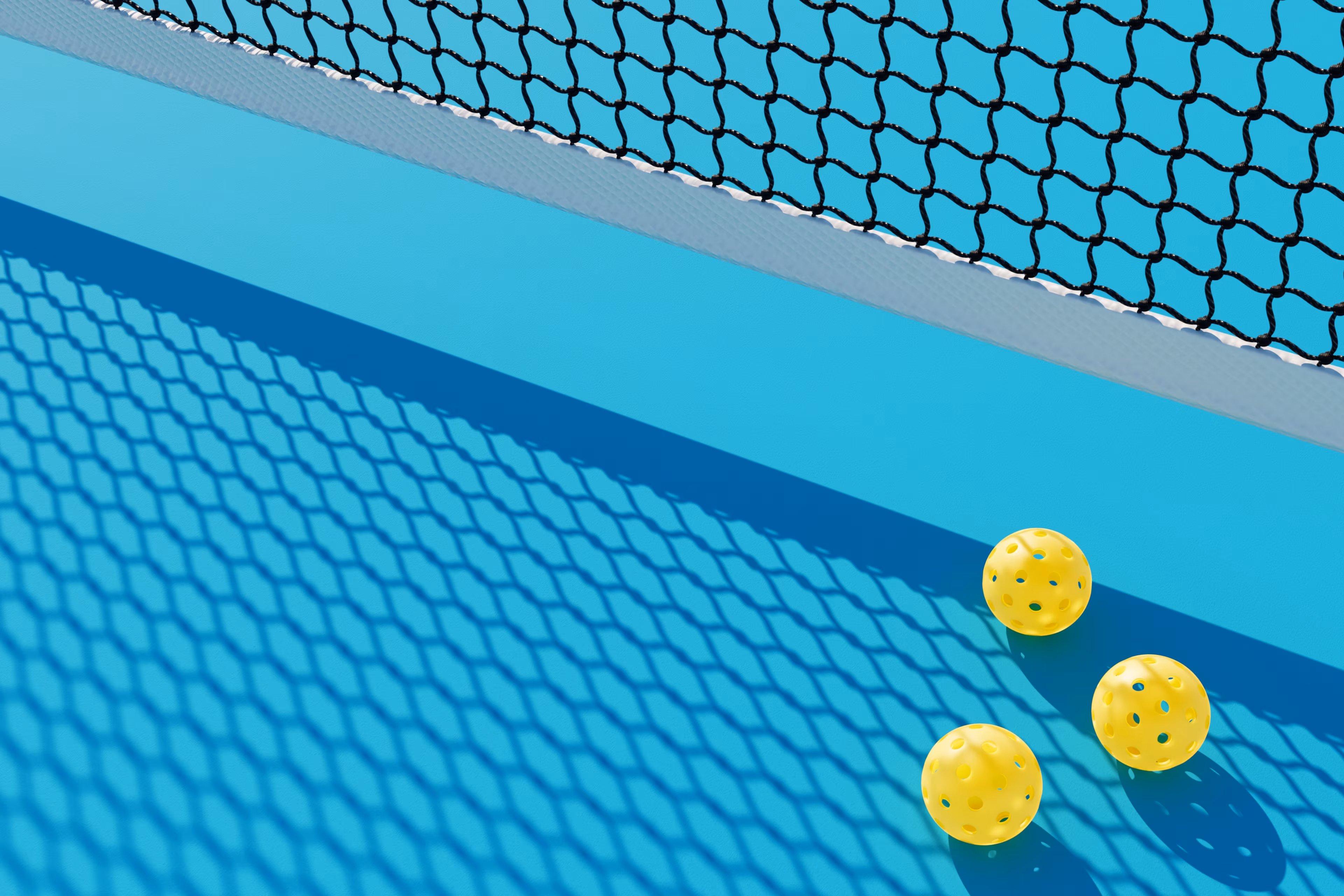 3 Pickleball-Bälle unter einem Netz