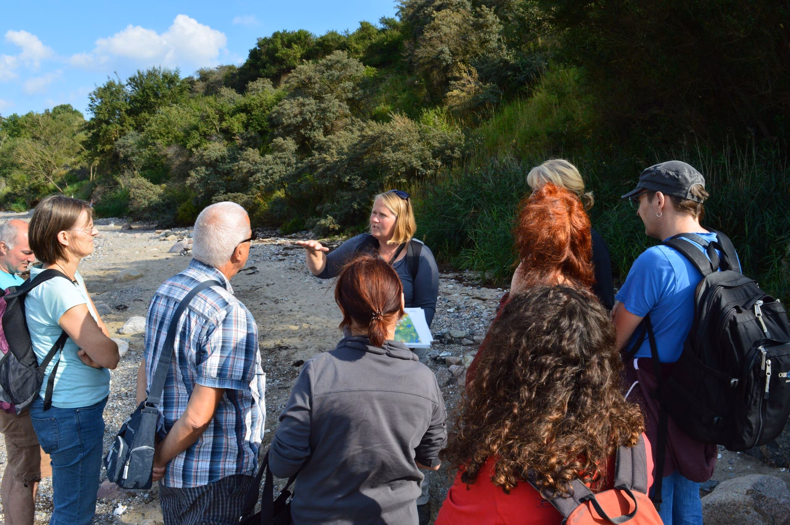 Geologin Kerstin Pfeiffer mit einer Gruppe bei einer Stein-Exkursion in Boltenhagen