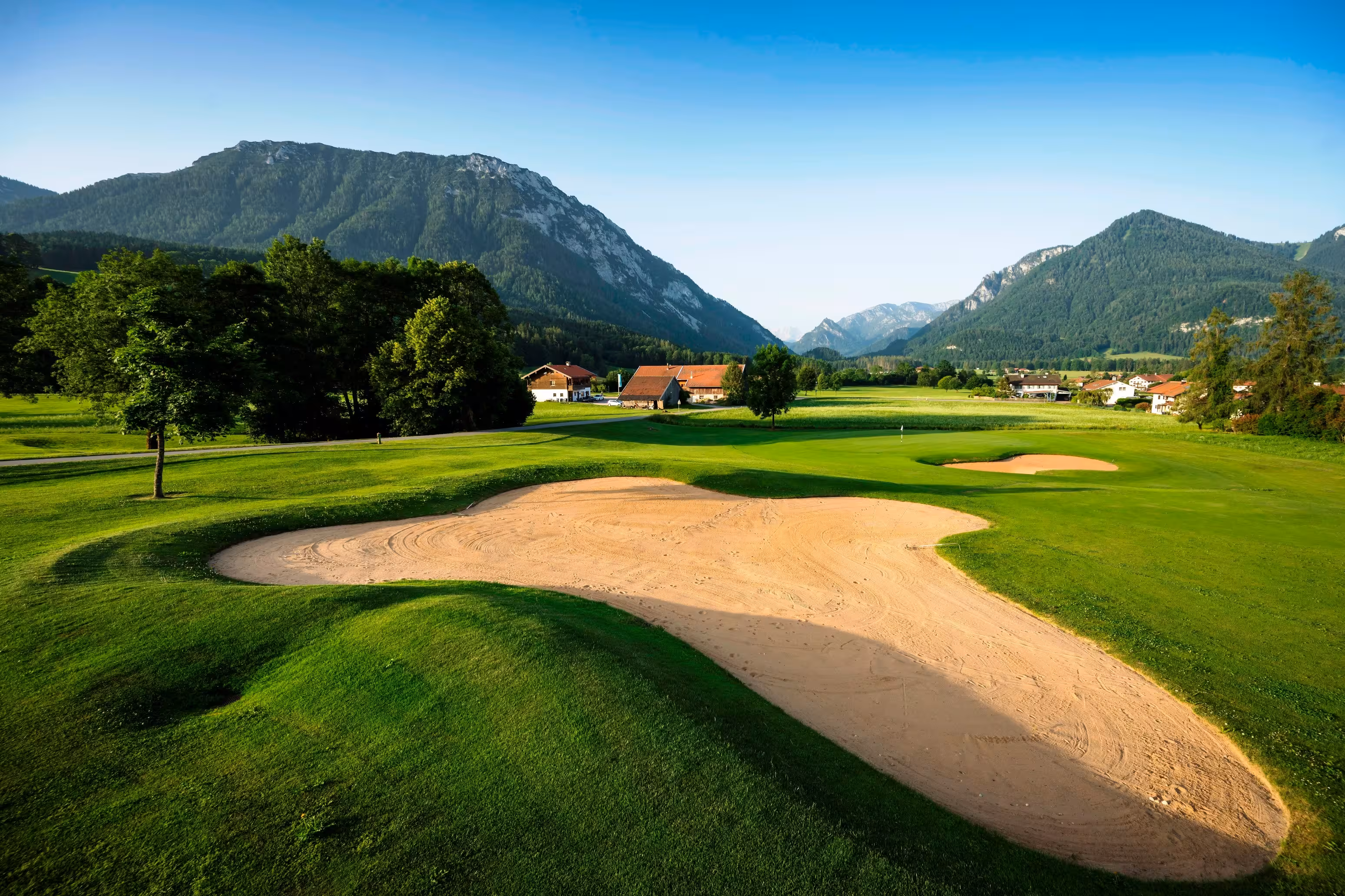 Ein Sandbunker auf dem Golfplatz Ruhpolding mit den Alpen im Hintergrund