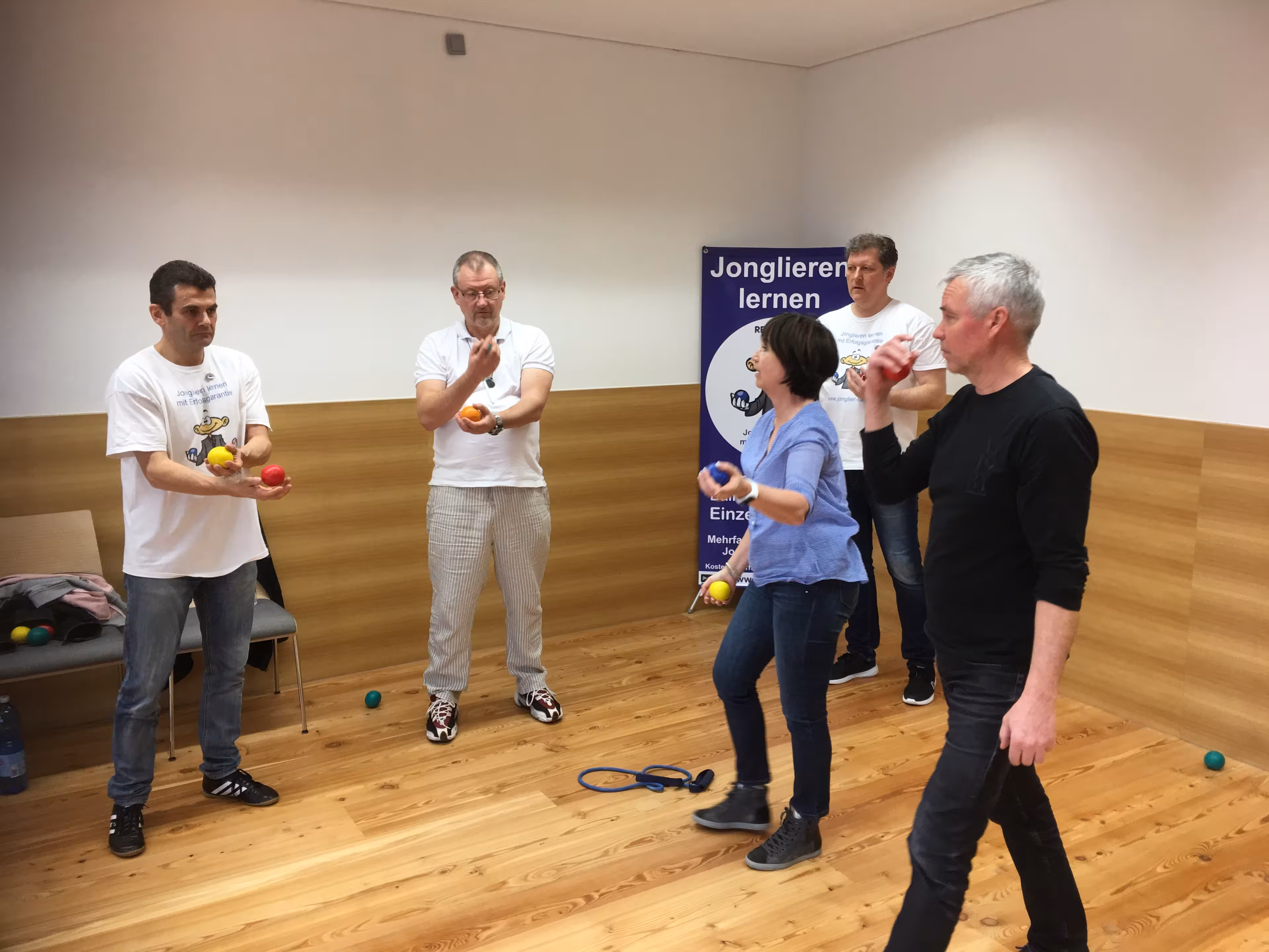 Teilnehmende eines Jonglier-Workshops machen Übungen mit Jonglierbällen