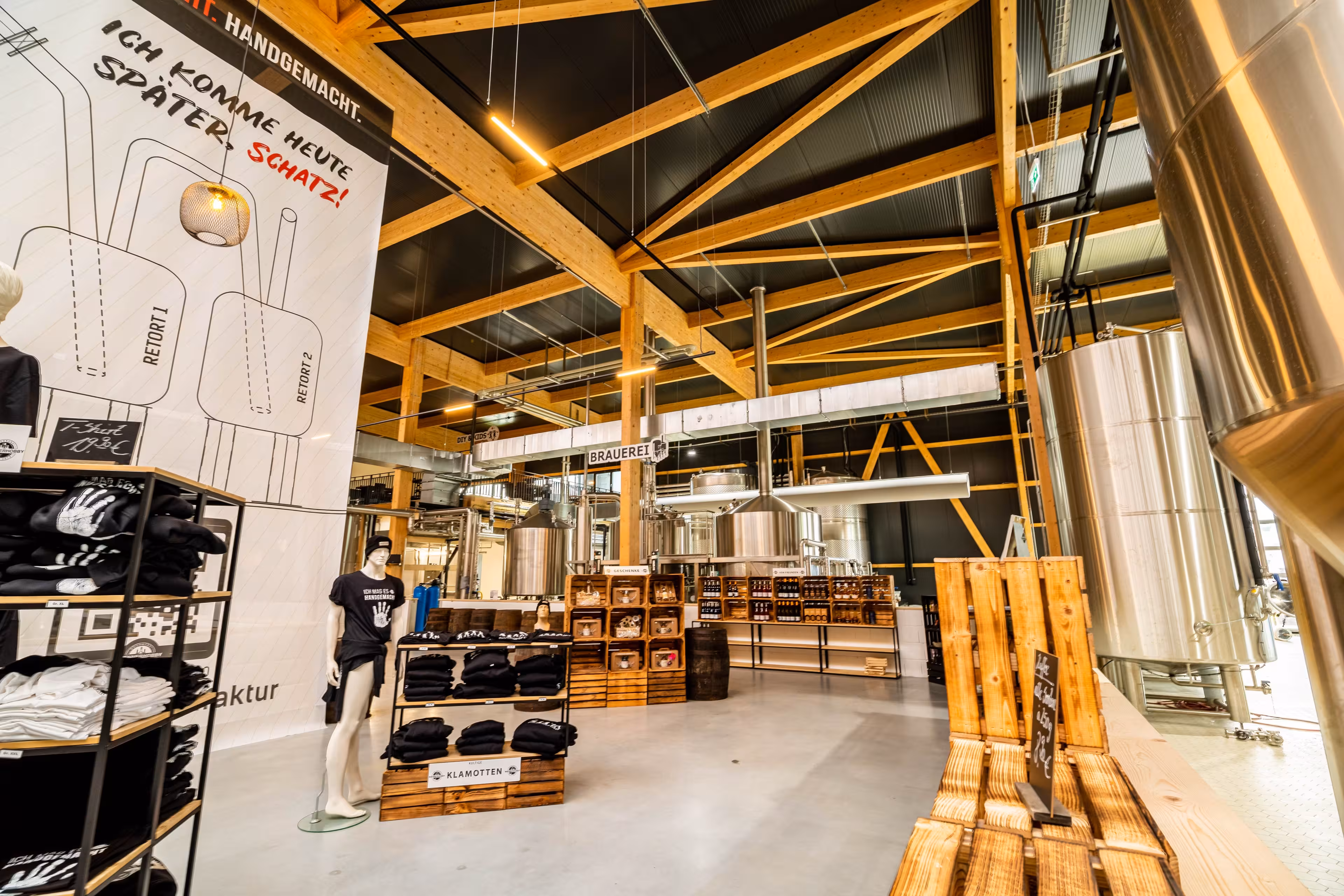 Eine Halle mit einer hölzernen Deckenkonstruktion und Regalen mit Männerhobby-Merchandise