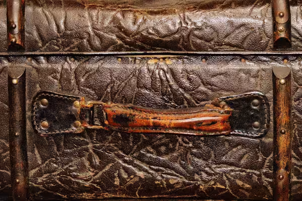 Detailansicht eines alten Lederkoffers mit abgenutztem Griff.