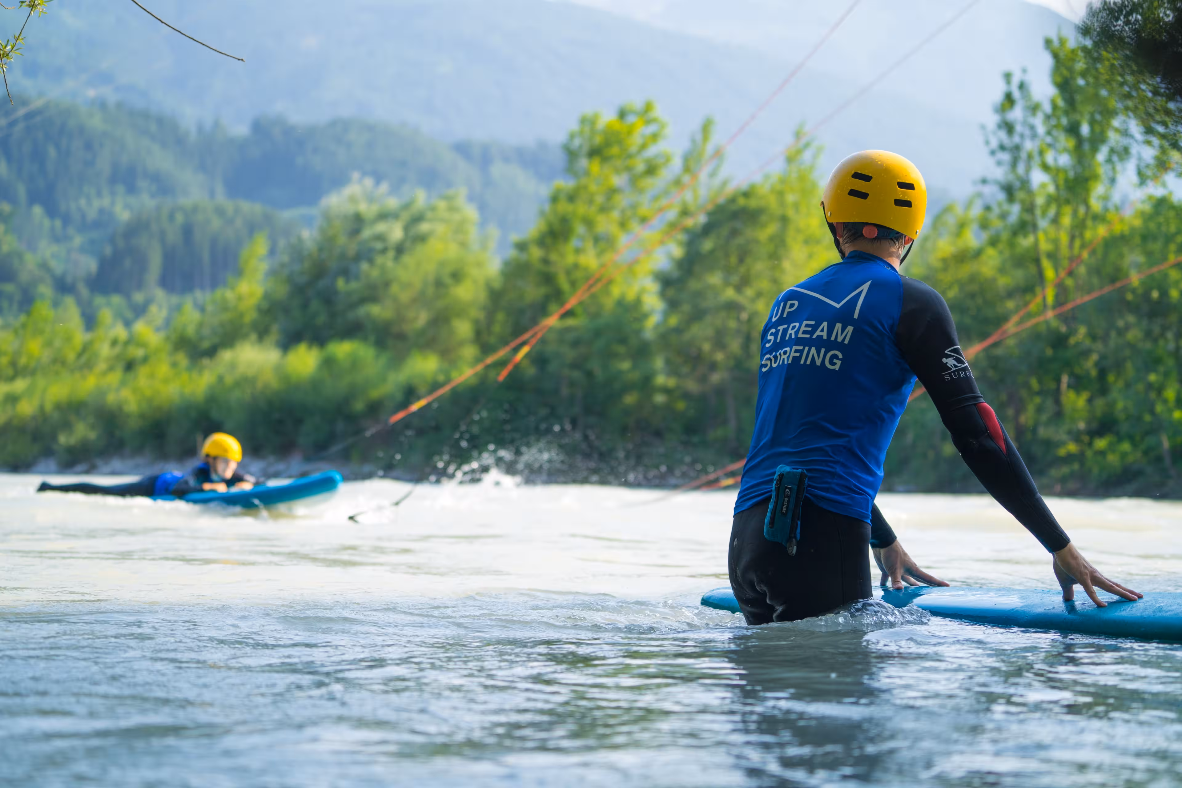 Eine Frau liegt auf einem Surfbrett auf dem Inn