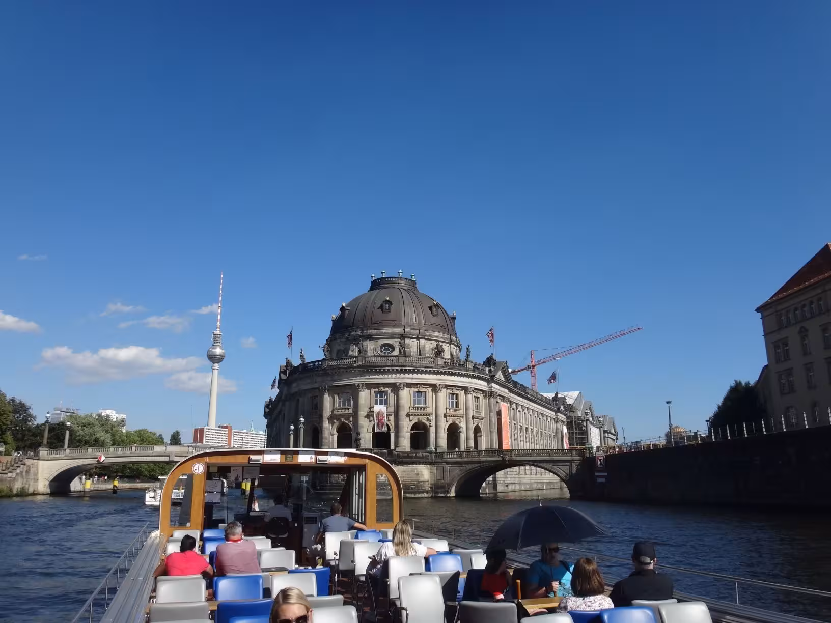 Personen auf einem Fahrgastschiff bei einer City-Tour auf der Spree durch Berlin