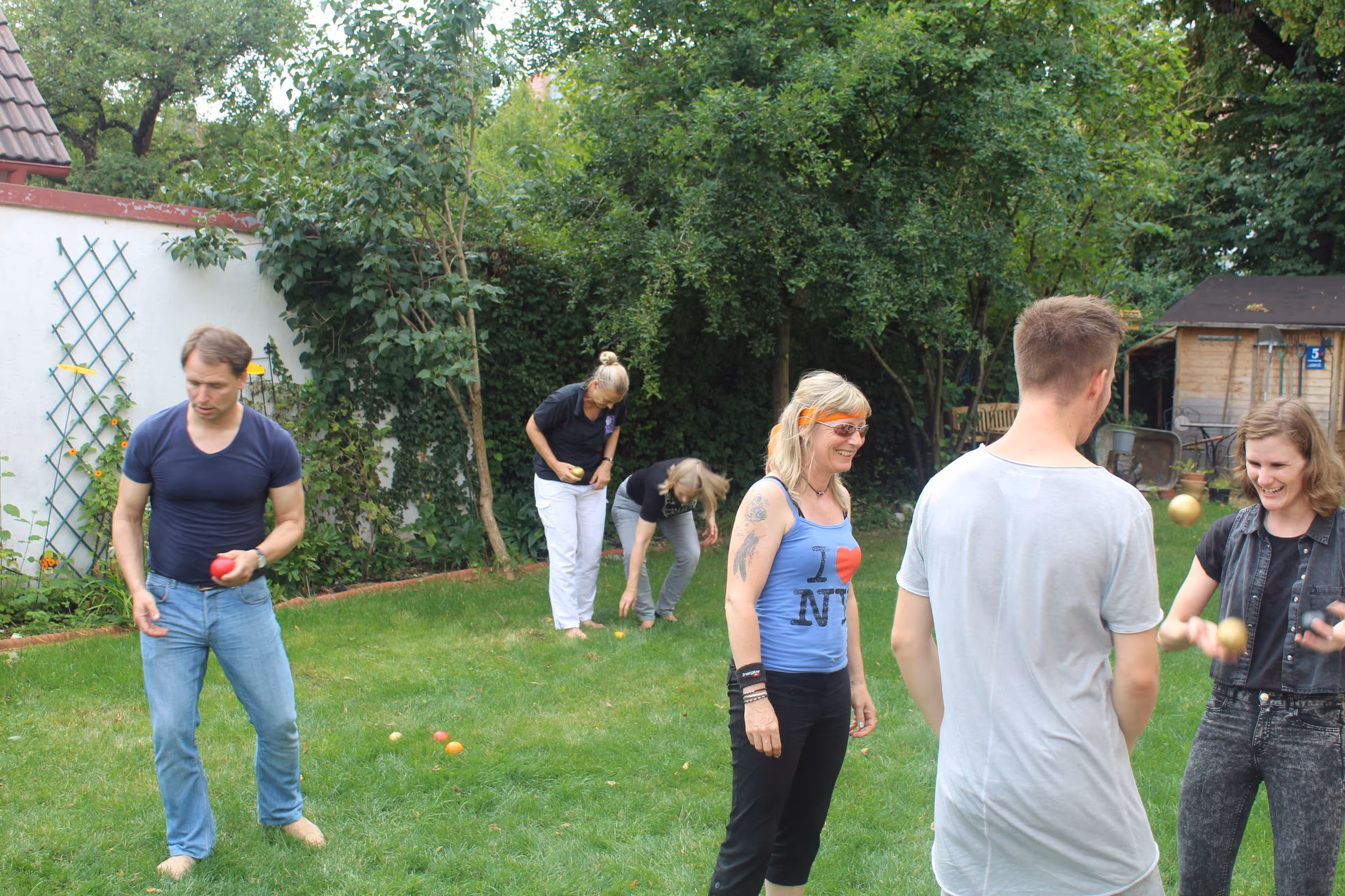 Teilnehmende eines Jonglier-Workshops machen Übungen mit Jonglierbällen