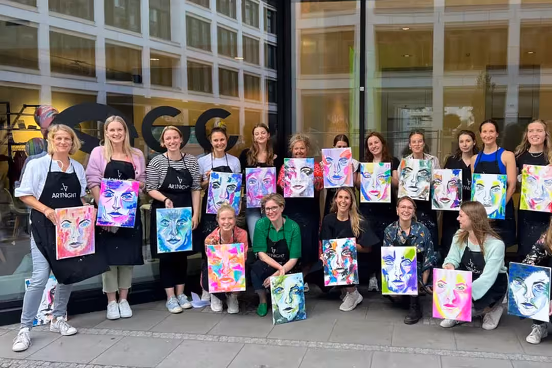 Eine Gruppe von Frauen zeigt ihre Kunstwerke vor einem Gebäude nach dem Gruppenevent der ArtNight.
