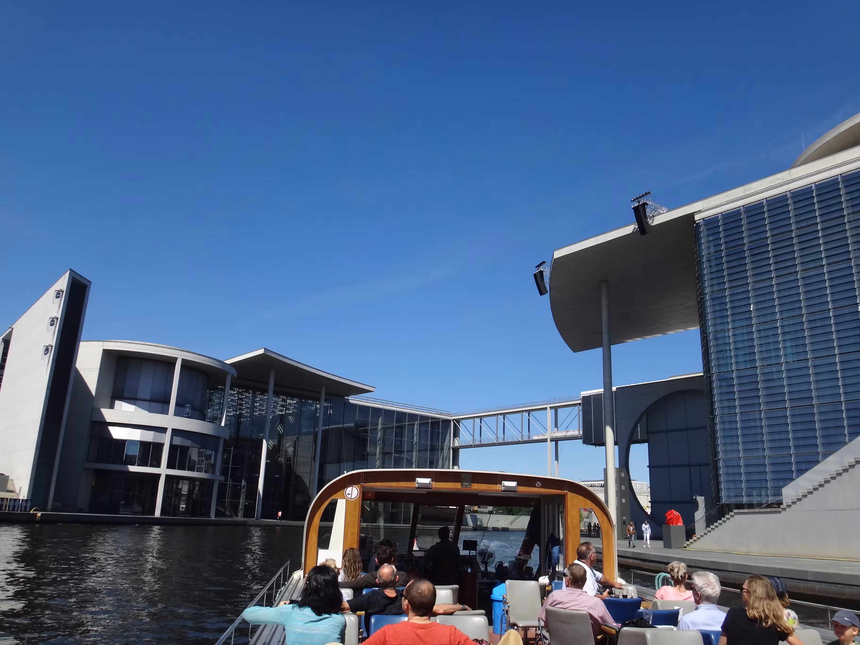 Personen auf einem Fahrgastschiff bei einer City-Tour auf der Spree durch Berlin