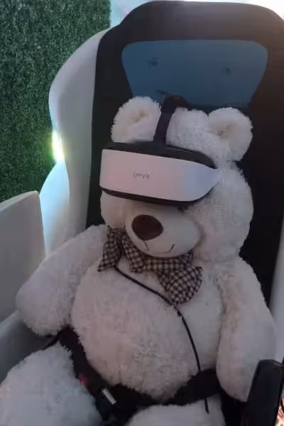 Ein Teddy trägt eine VR-Brille und sitzt im VR-Kino.