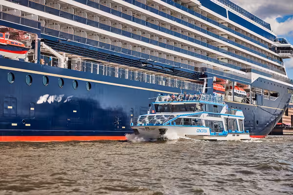 Fahrgastschiff fährt am Kreuzfahrtschiff vorbei
